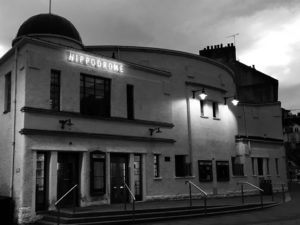External view of art deco cinema in black and white.