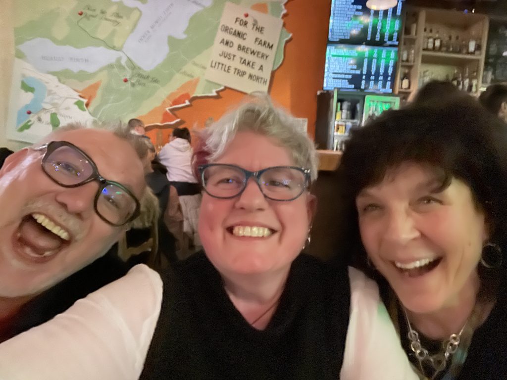 3 people grinning maniacally into the camera in the Black Isle Brewery bar. 